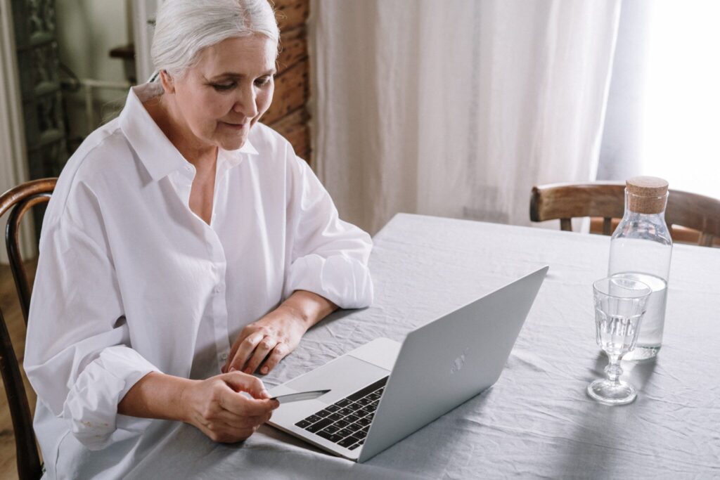older woman sitting at table on laptop